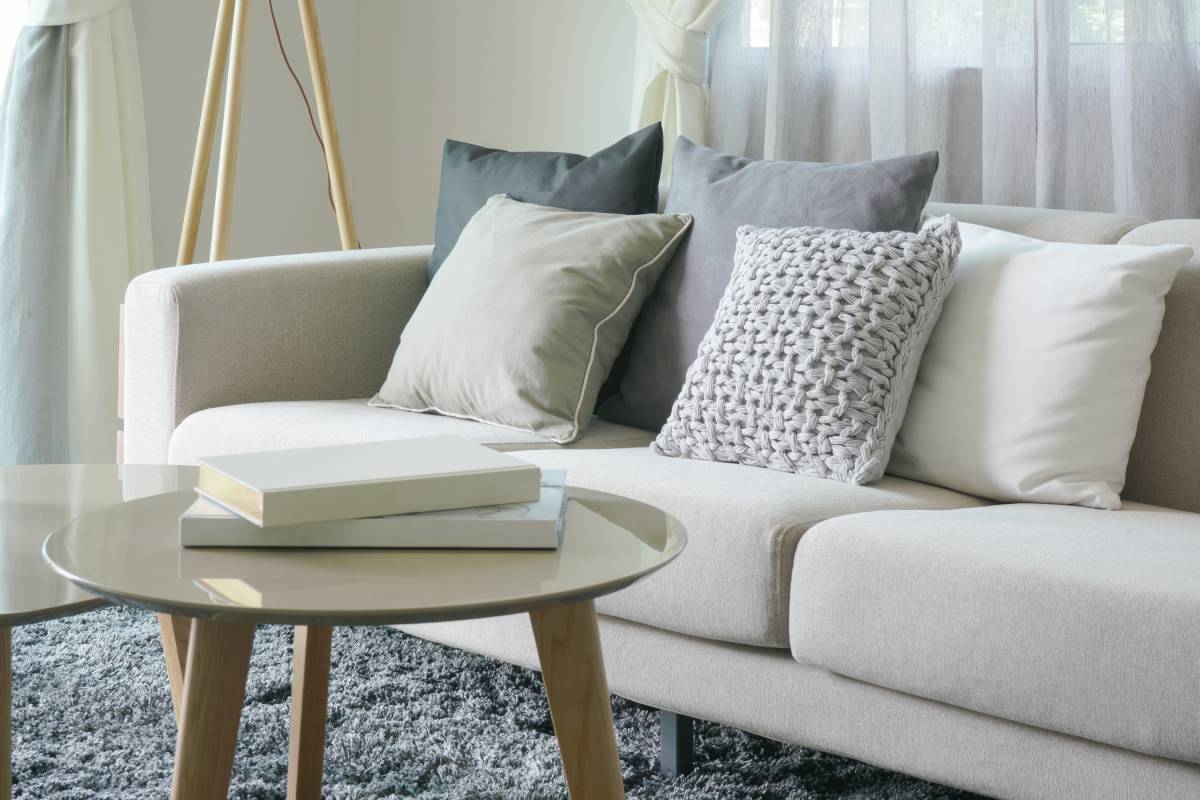 Living room sofa with throw pillows next to a set of small coffee tables near Florence, KY