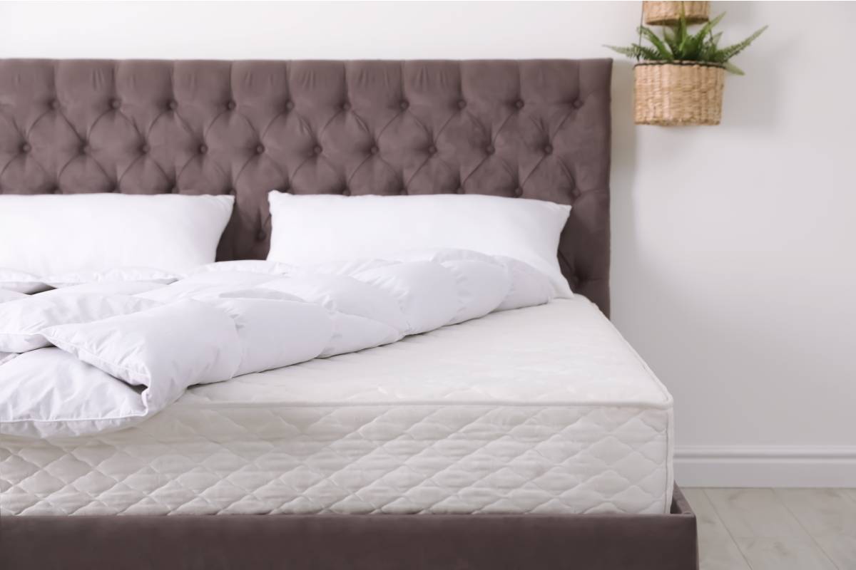 King size mattress on a bed frame with pillows and comforter near Florence, KY