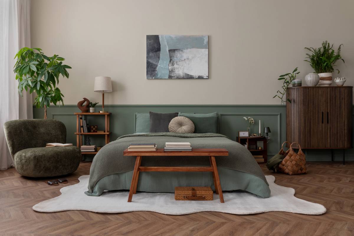 Mid century modern bedroom with large bed, table, accent chair, and cabinet.